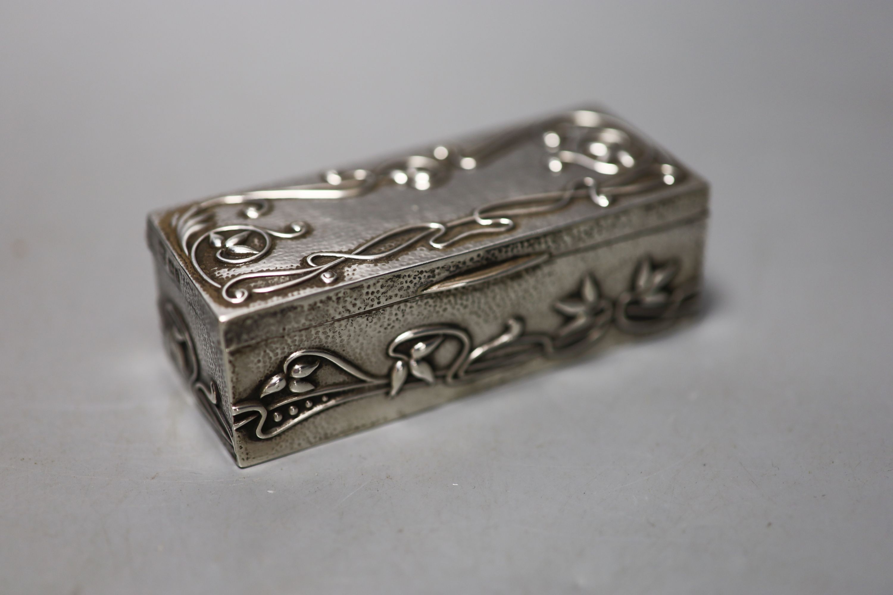 A late 19th century German embossed 800 standard white metal rectangular box, 12.2cm, three smaller boxes, including two silver and a match sleeve.